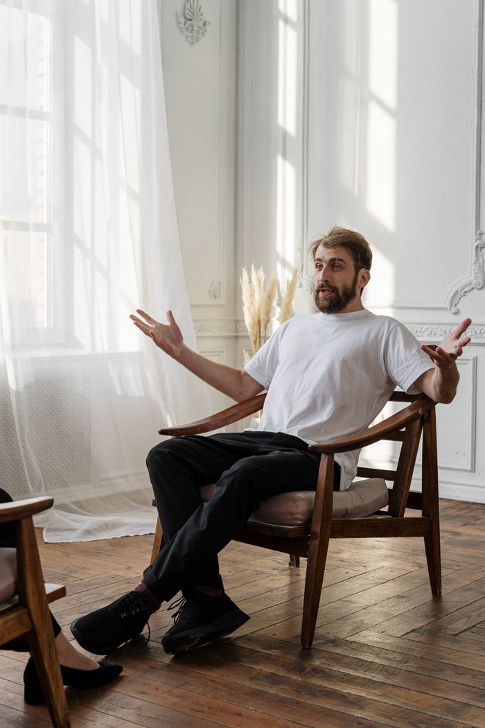 about-01 A therapist discusses with a patient in a bright, sunlit room for a mental health session.